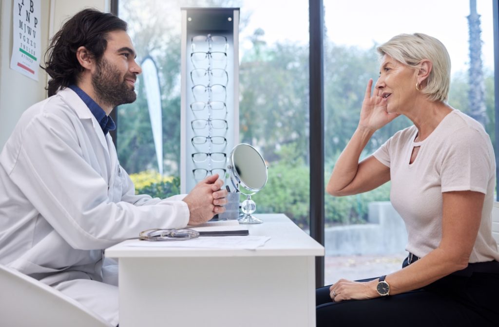 An optometrist talking to his patient in an eye clinic