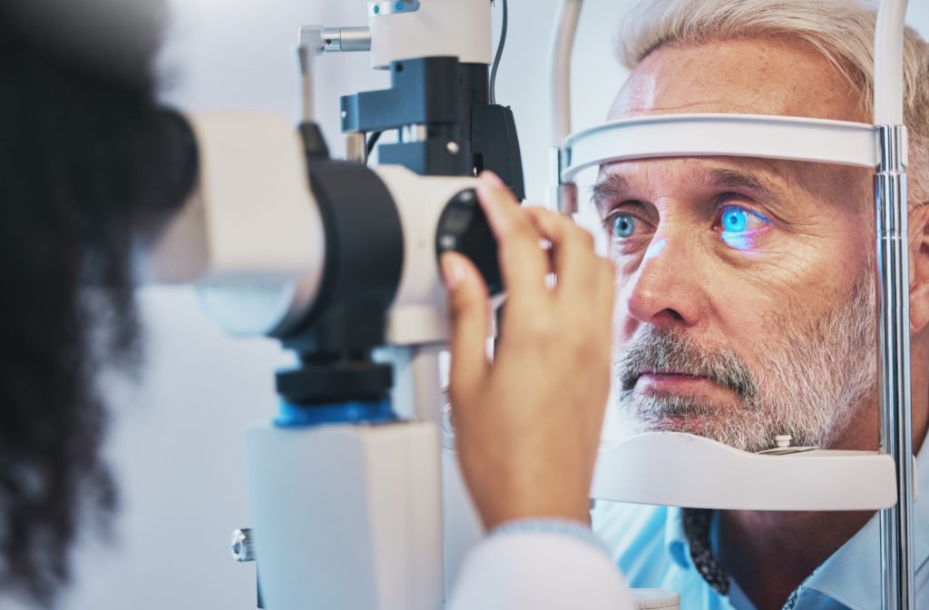 A senior man visiting his ophthalmologist for an eye exam to be diagnosed with cataracts.