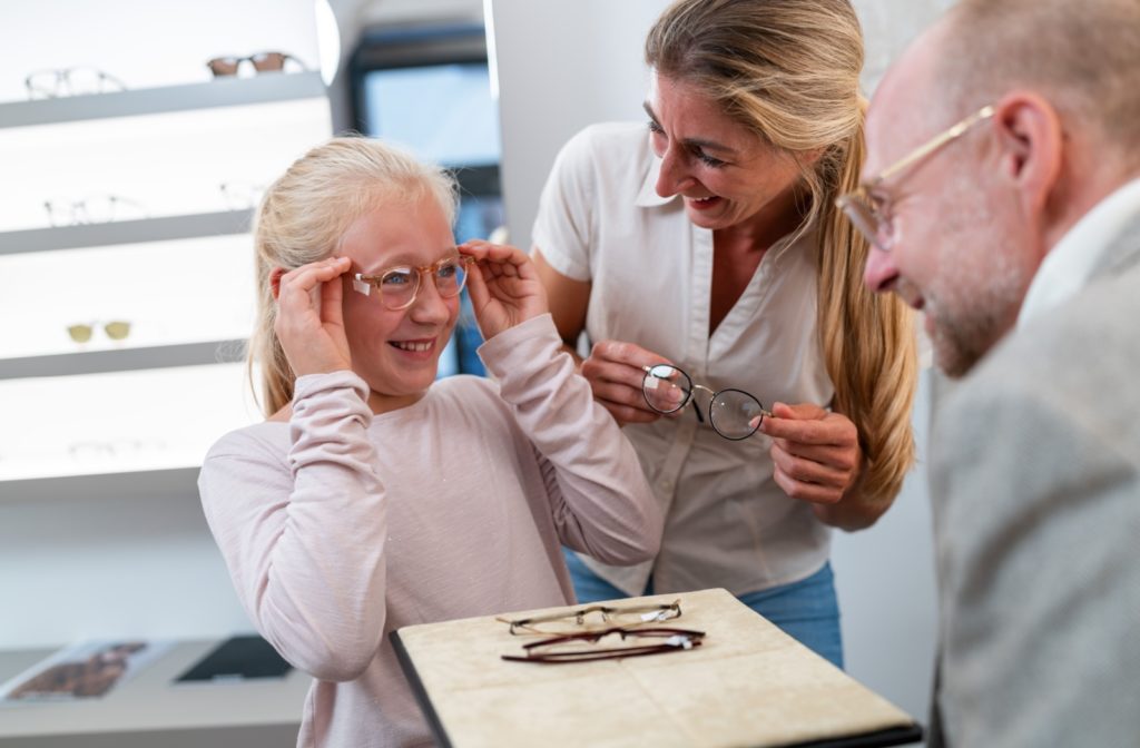  A young child trying on a pair of glasses while browsing for new frames.