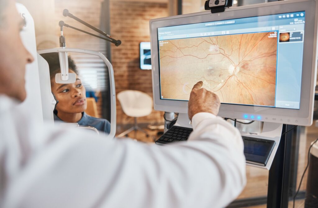 An optometrist points to a patient's retinal photos and discusses their macular health.