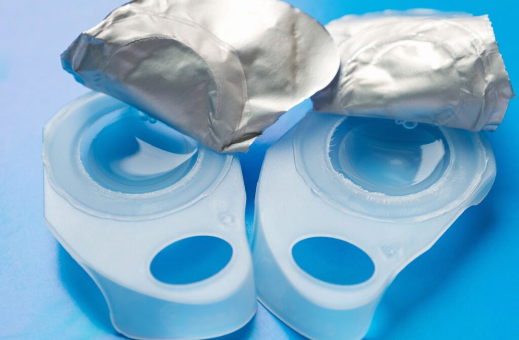 Two open blister packs show a contact lens resting inside the buffered solution.