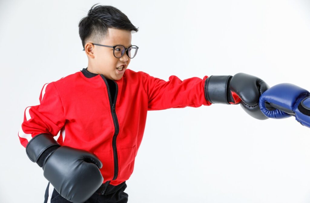 A child wearing glasses while boxing